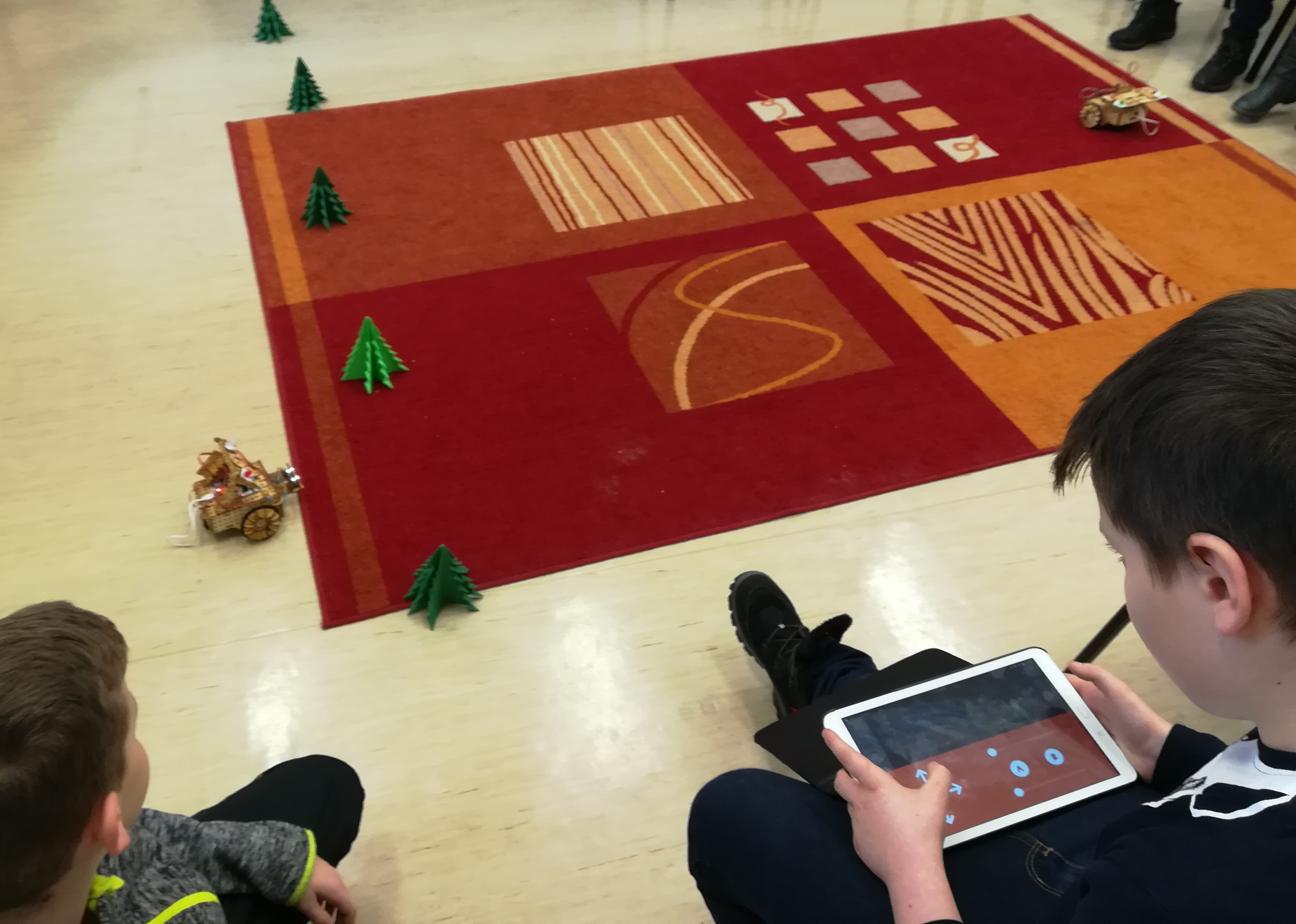 Dzieci programują robota w aplikacji na tablecie.