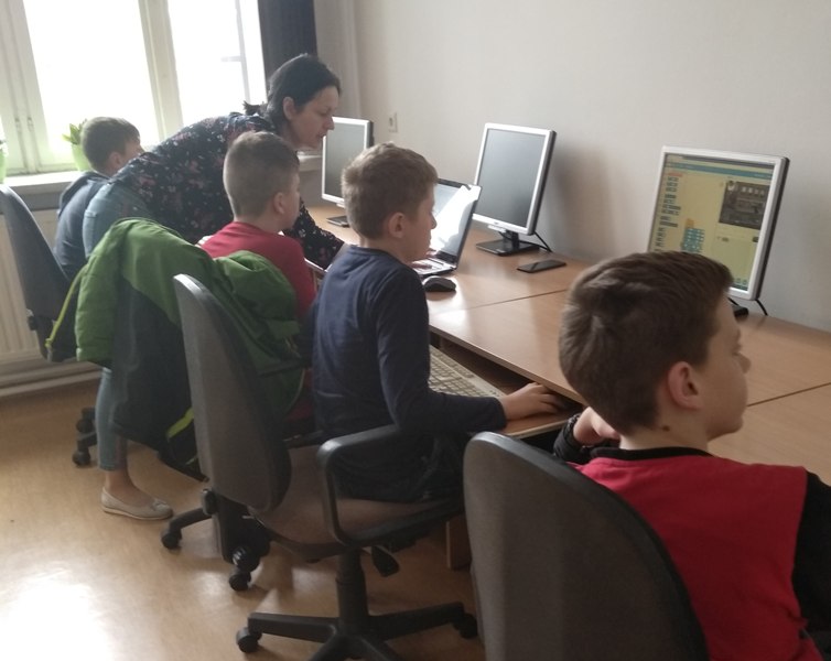 Uczniowie pracują na komputerach podczas zajęć z programowania. 