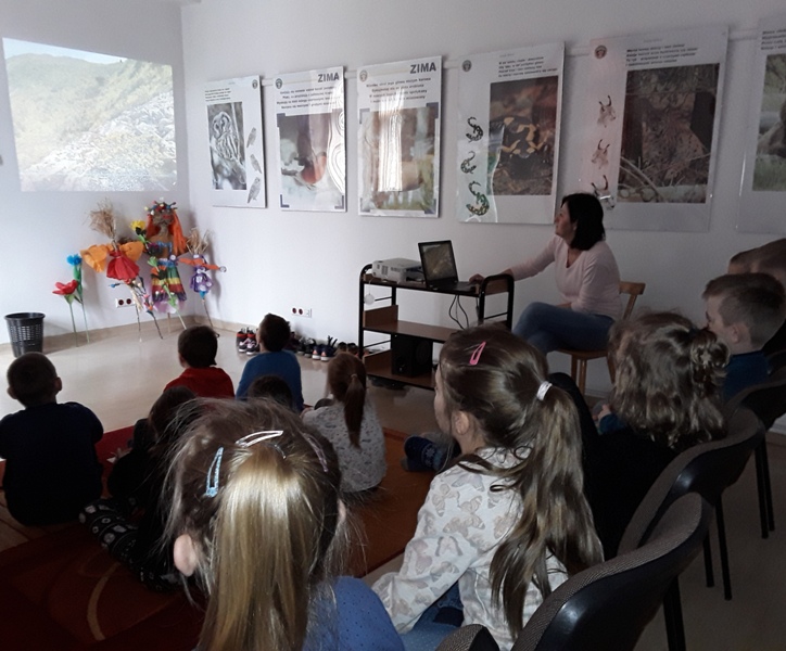 Pani wyświetla dzieciom film o przyrodzie Babiogórskiego Parku Narodowego.