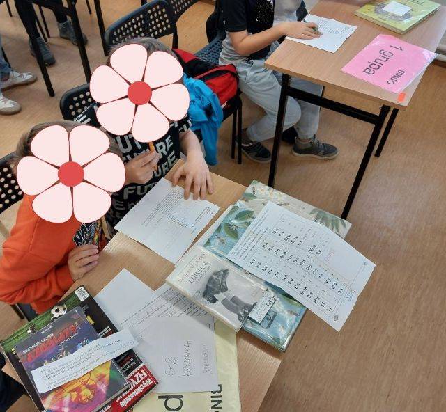 Biblioteczny escape room. Dzieci rozwiązują krzyżówki podczas bibliotecznego escape roomu.